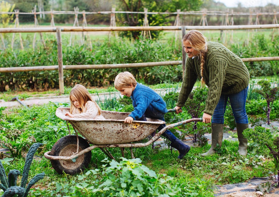 Jardinage en famille, mère qui porte ses enfants